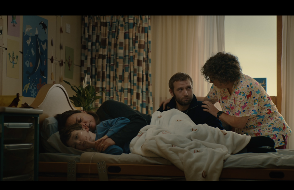 Still from CHAS TV advert featuring a child nearing end of life with his parents and being supported by CHAS Senior Charge Nurse Jane Carter