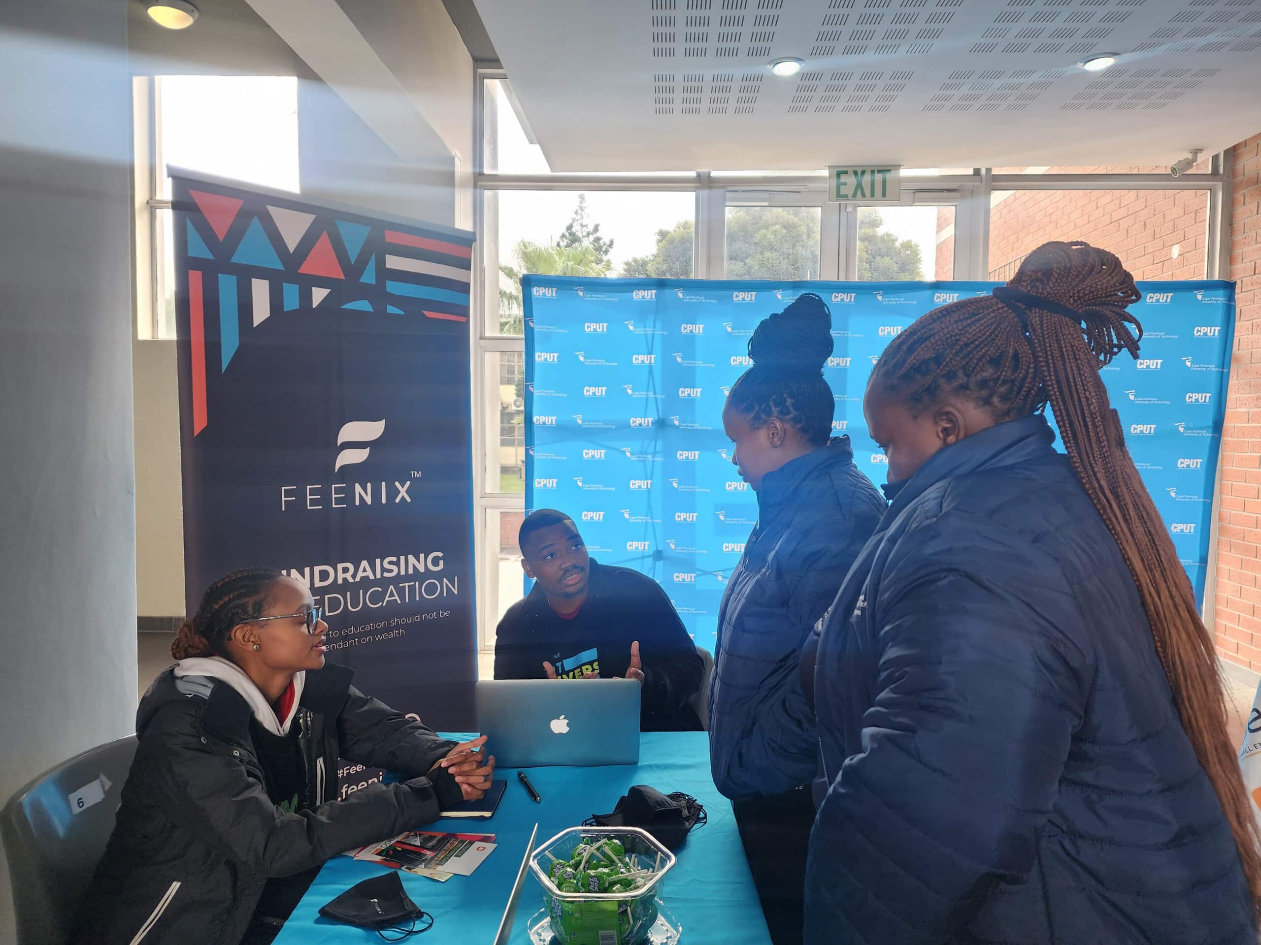Students talking with Feenix team members at a stand.