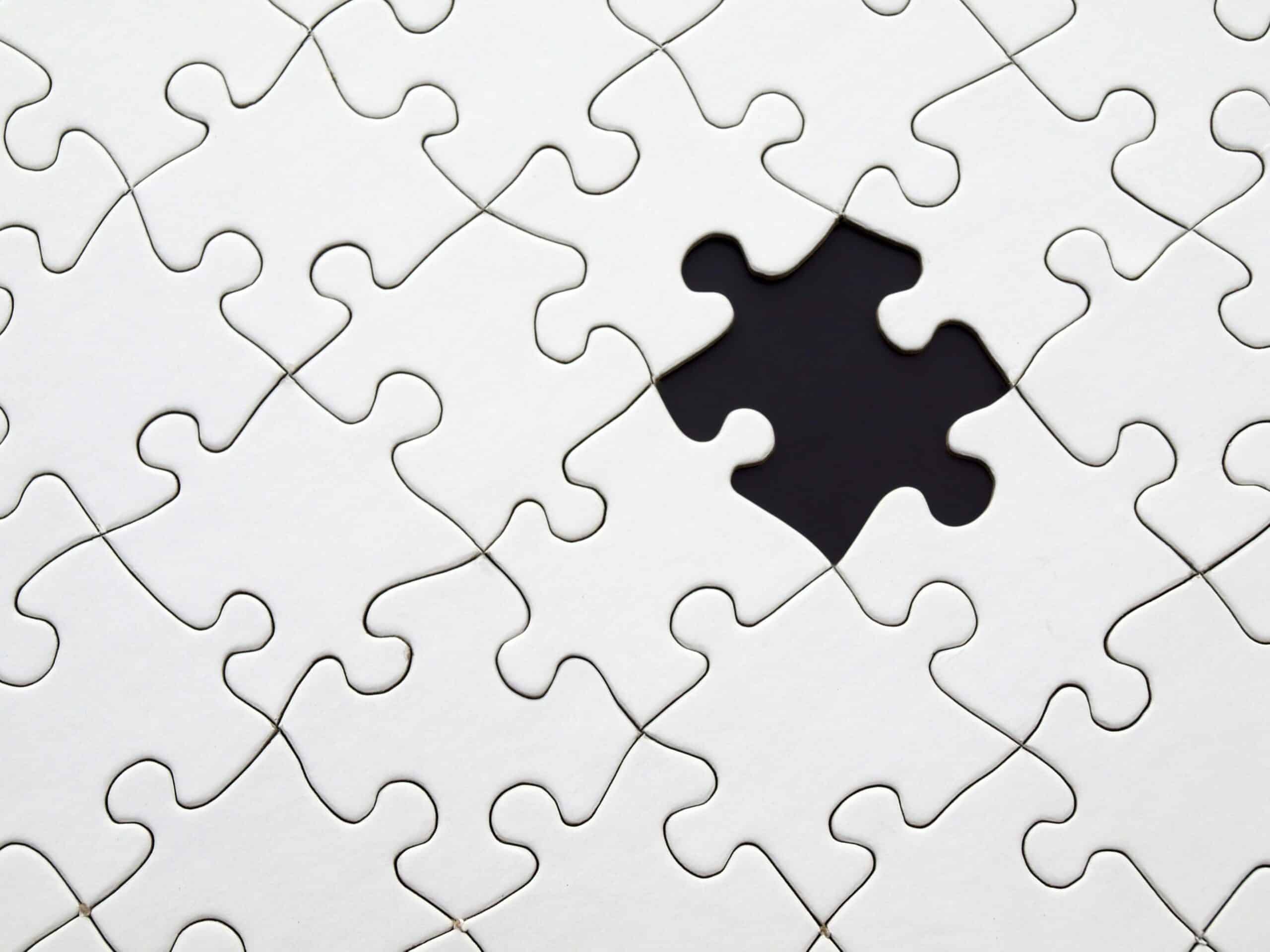 Jigsaw puzzle with one missing piece showing a black background behind.