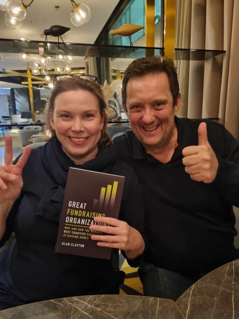 Salla Saarinen and Alan Clayton with a copy of his book 'Great Fundraising Organizations'.